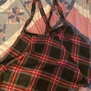 Mid thigh skirt with cross straps and tag still on it, red and black checkered